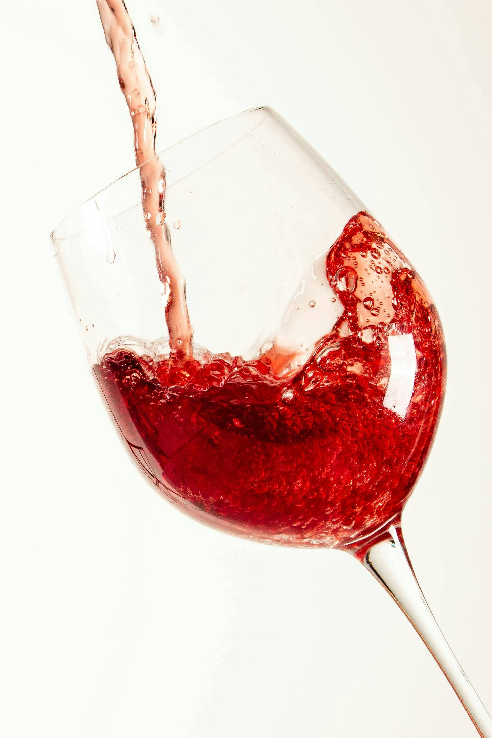 Roter Flüssigkeit wird in ein Glas eingeschenkt
