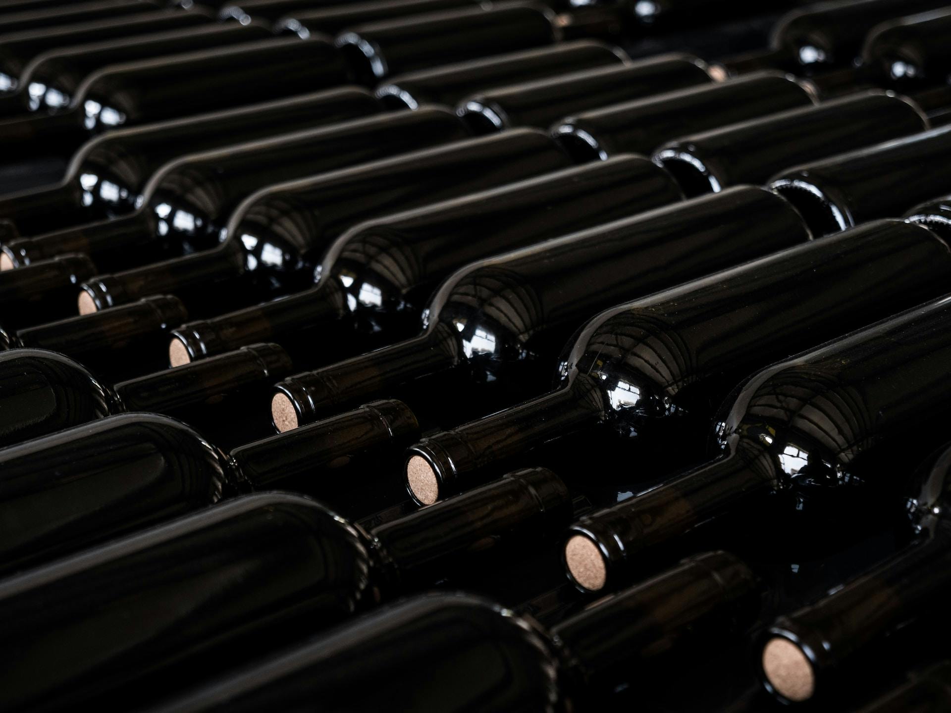 Schwarze Weinflaschen nebeneinader gelegt ohne Etikett