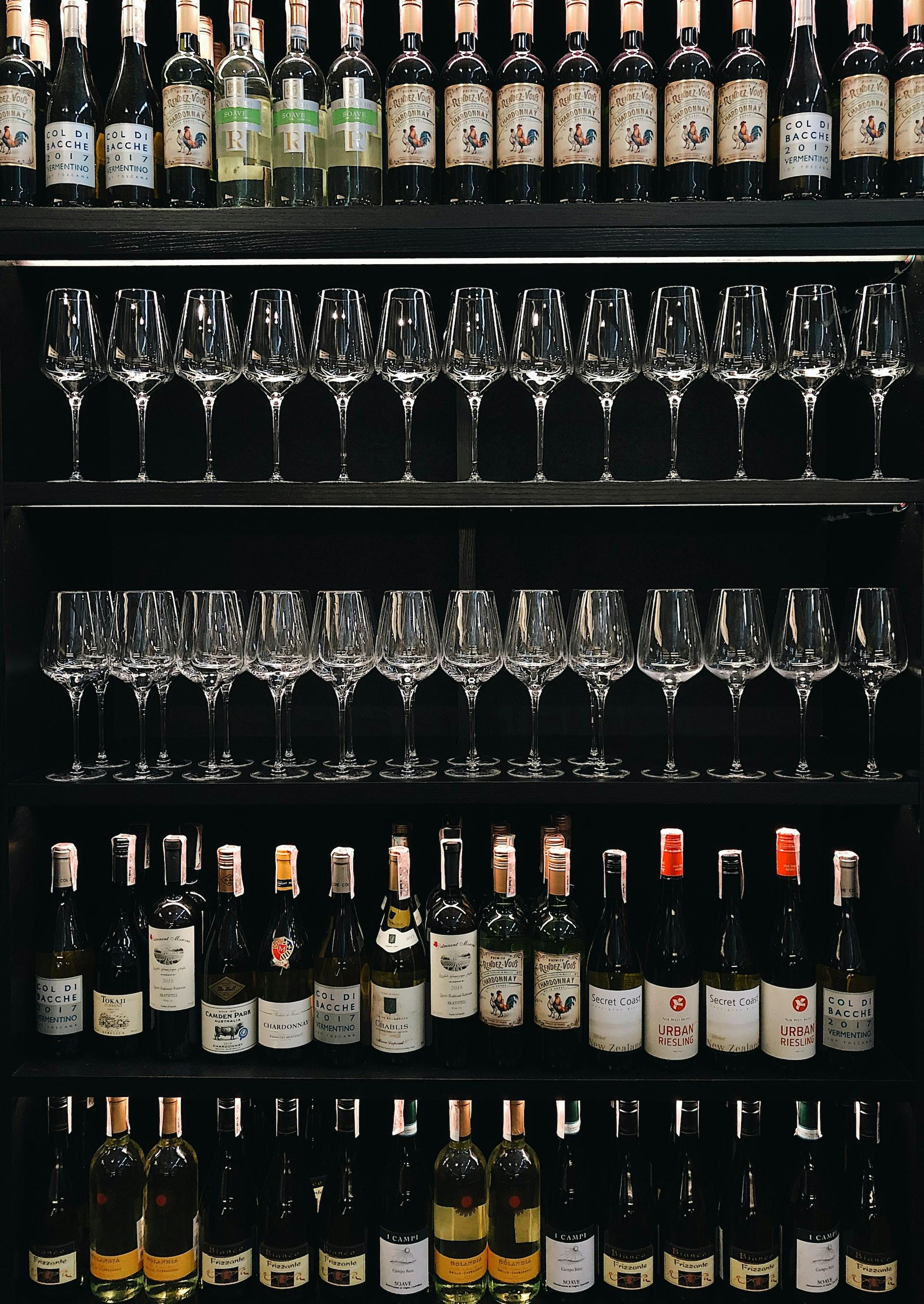 Schwarzes Regal mit Weinflaschen und Weingläsern