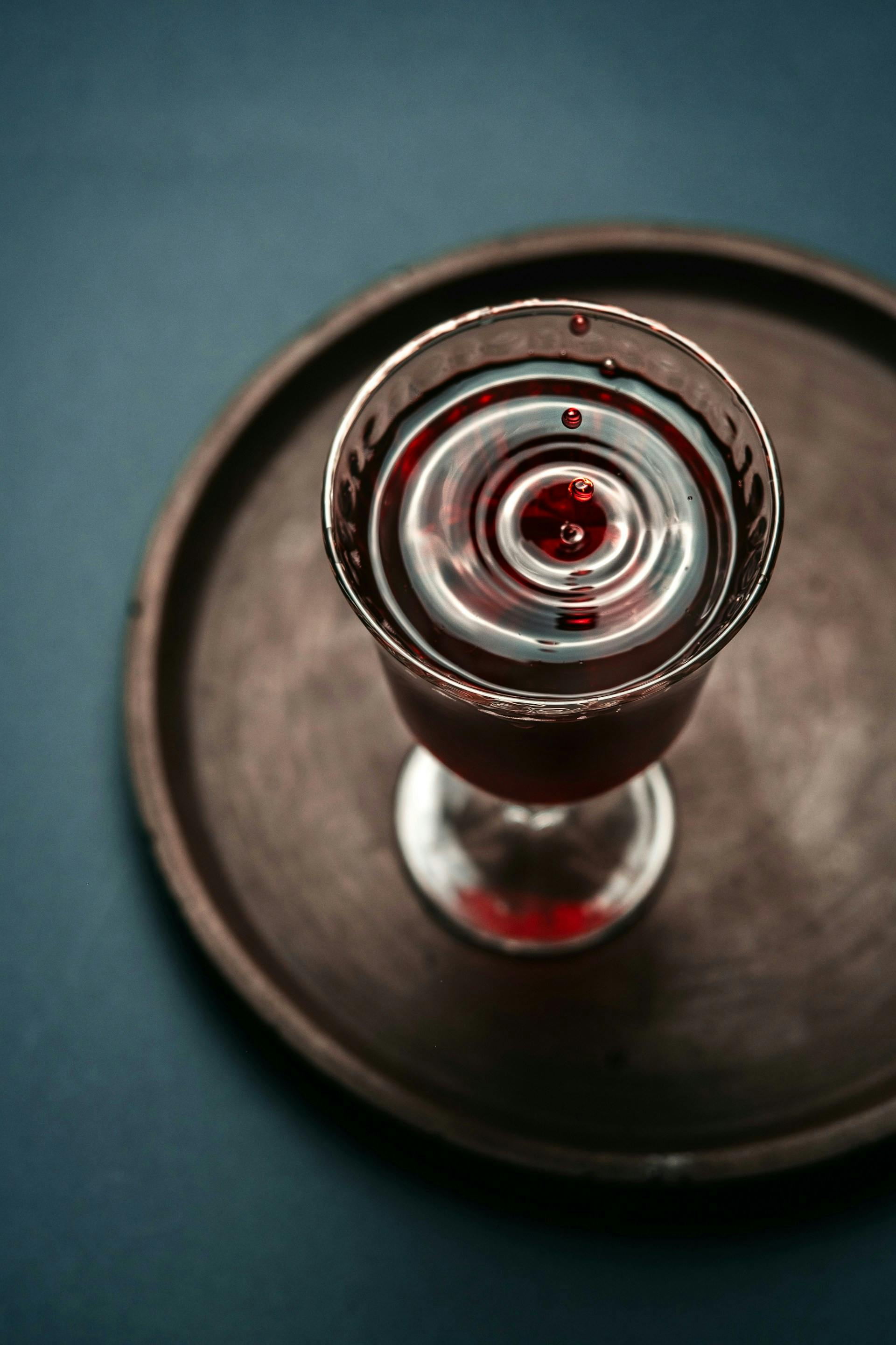 Glas mit Rotwein auf braunem Tablett 