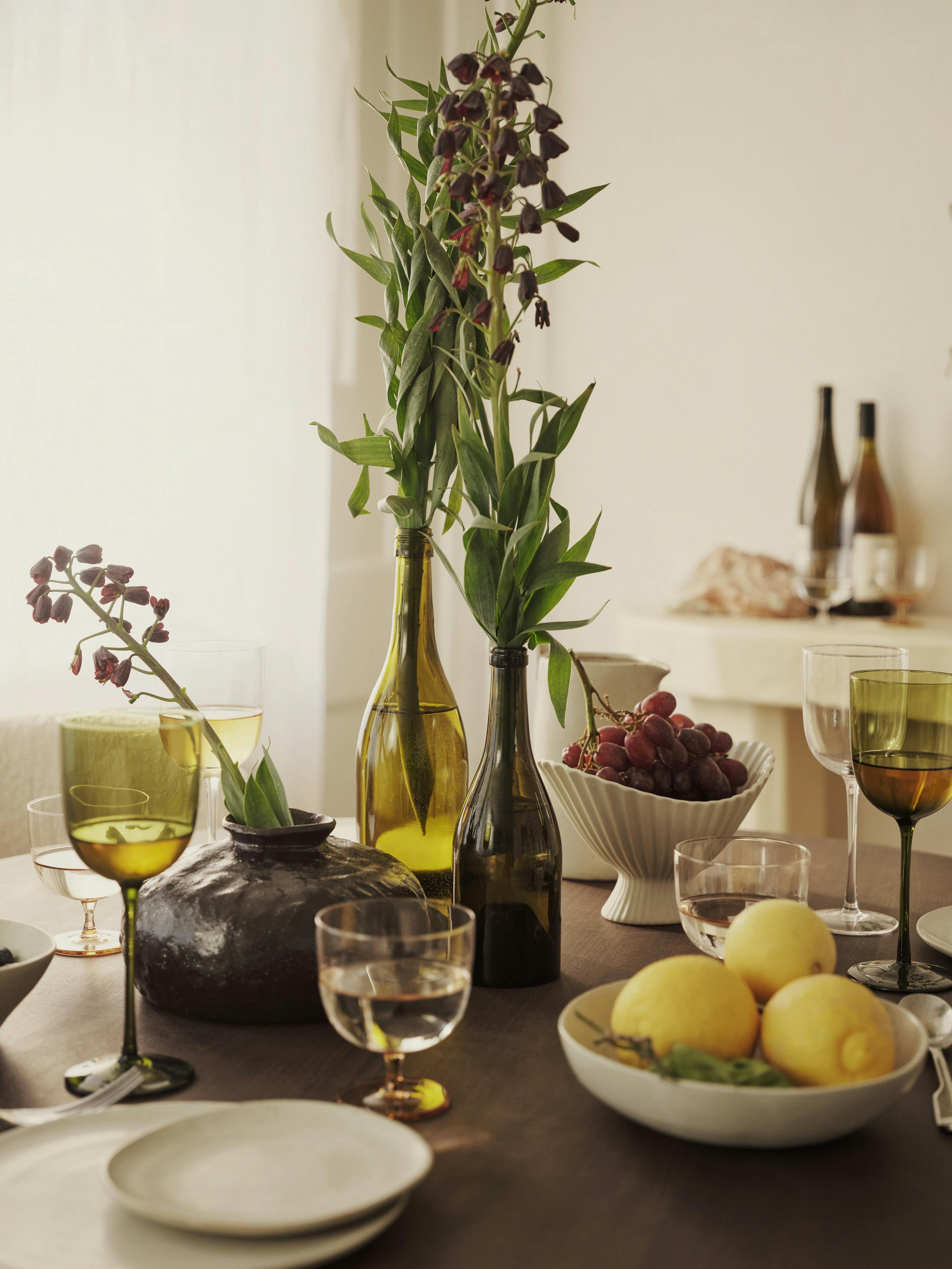 Schön gedeckter Tisch mit Schale Zitronen und Blumen