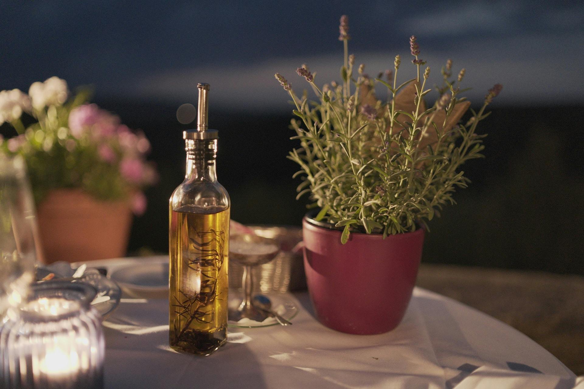 Flasche mit Öliger Flüssigkeit auf Tisch mit Pflanze daneben