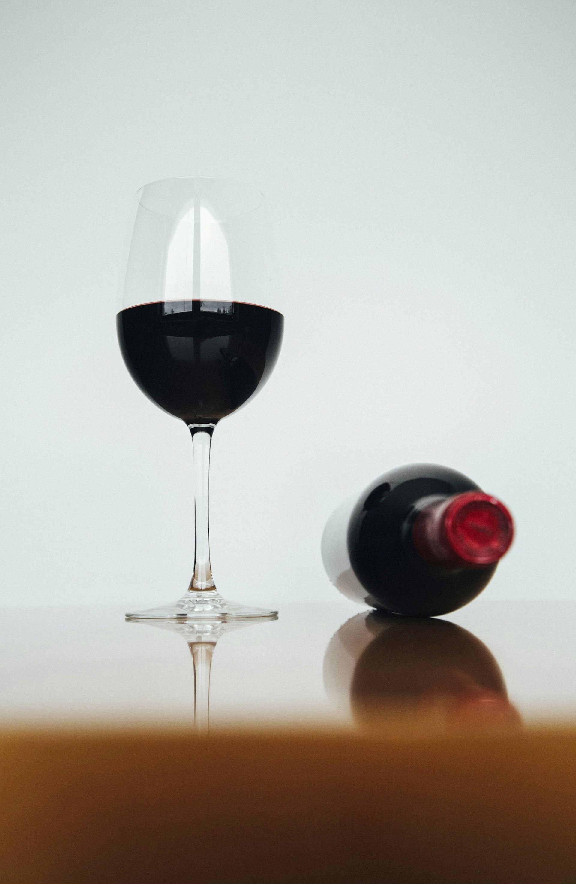 Glas Rotwein neben Flasche